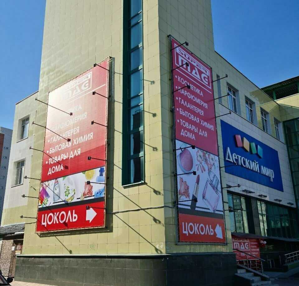 Монтаж баннера на фасаде торгового центра для магазина косметики и парфюмерии в г. Бердск Производство и монтаж баннеров на фасадах зданий